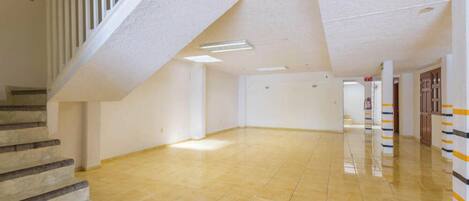 Ein geräumiger, gut beleuchteter Flur mit Fliesenboden und einer Treppe, die nach oben führt.