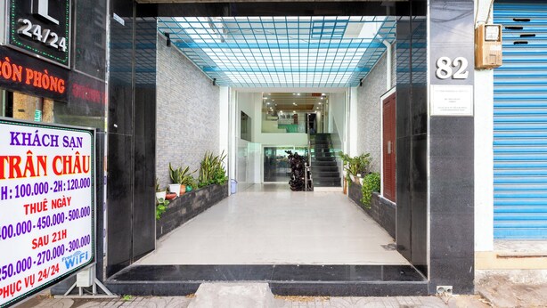 A hotel entrance with a tiled ceiling, a staircase, and a signboard with room rates. - Tran Chau Hotel Q4 SG - by BAY LUXURY (Ho Chi Minh City)