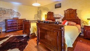 A traditional bedroom with a wooden bed, a dresser, and a stone wall. - Charming Holiday Home With Garden (Tar-Vabriga)