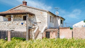 A stone house with a tiled roof, a staircase, and a satellite dish. - Charming Holiday Home With Garden (Tar-Vabriga)