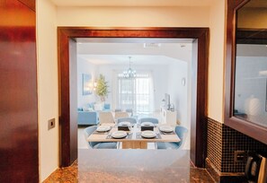 Enjoy meals in this stylish dining area with a central light fixture, modern art pieces, and a large window.