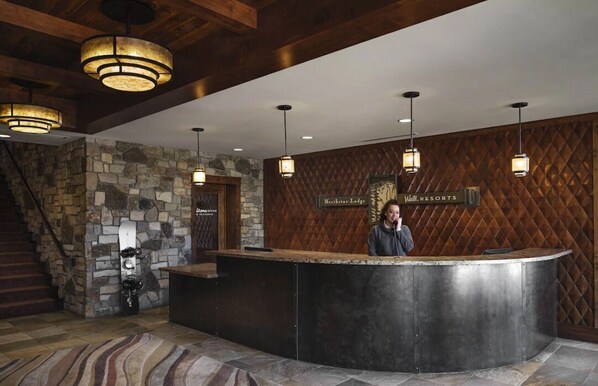 A reception area with a stone wall, a wooden reception desk, and a sign for 'Northstar Lodge'.