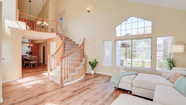 A spacious living area with a wooden staircase, large windows, and a cozy seating area. - SUNNY SPACIOUS RETREAT NEAR GOLF COURSE W/ HOT TUB - WINE COUNTRY GETAWAY  (Windsor)