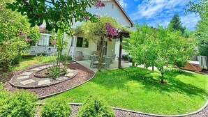 A house with a garden, a patio with outdoor furniture, and a clear sky. - SUNNY SPACIOUS RETREAT NEAR GOLF COURSE W/ HOT TUB - WINE COUNTRY GETAWAY  (Windsor)