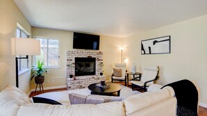 A living room with a brick fireplace, a sofa, a coffee table, and a chair. - SUNNY SPACIOUS RETREAT NEAR GOLF COURSE W/ HOT TUB - WINE COUNTRY GETAWAY  (Windsor)