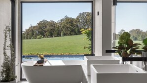 Une salle de bain moderne avec une grande fenêtre, une baignoire et un lavabo.