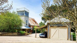 A two-story house with a garage, a covered porch, and a car parked in front.