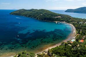 An aerial view of a coastal area with a beach, clear waters, and surrounding greenery. - RESIDENCE I DUE GOLFI - BILO 3/5 PT I DUE GOLFI (Capoliveri)