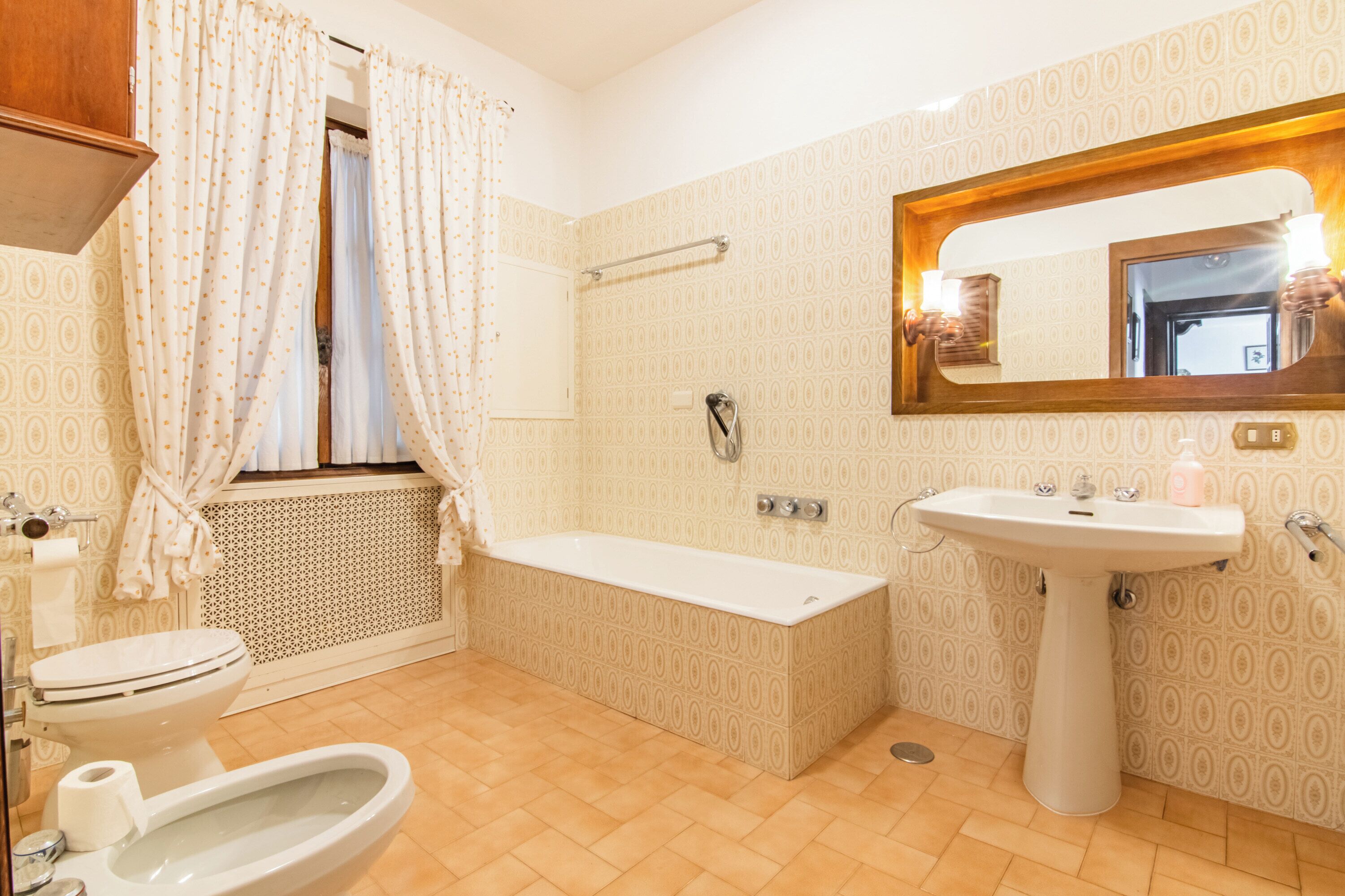 A bathroom with a toilet, bidet, bathtub, and sink.