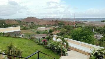 A residential area with a view of distant hills, a water body, and a tall communication tower.