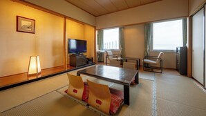 Una habitación de estilo japonés tradicional con suelo de tatami, una mesa baja y asientos.