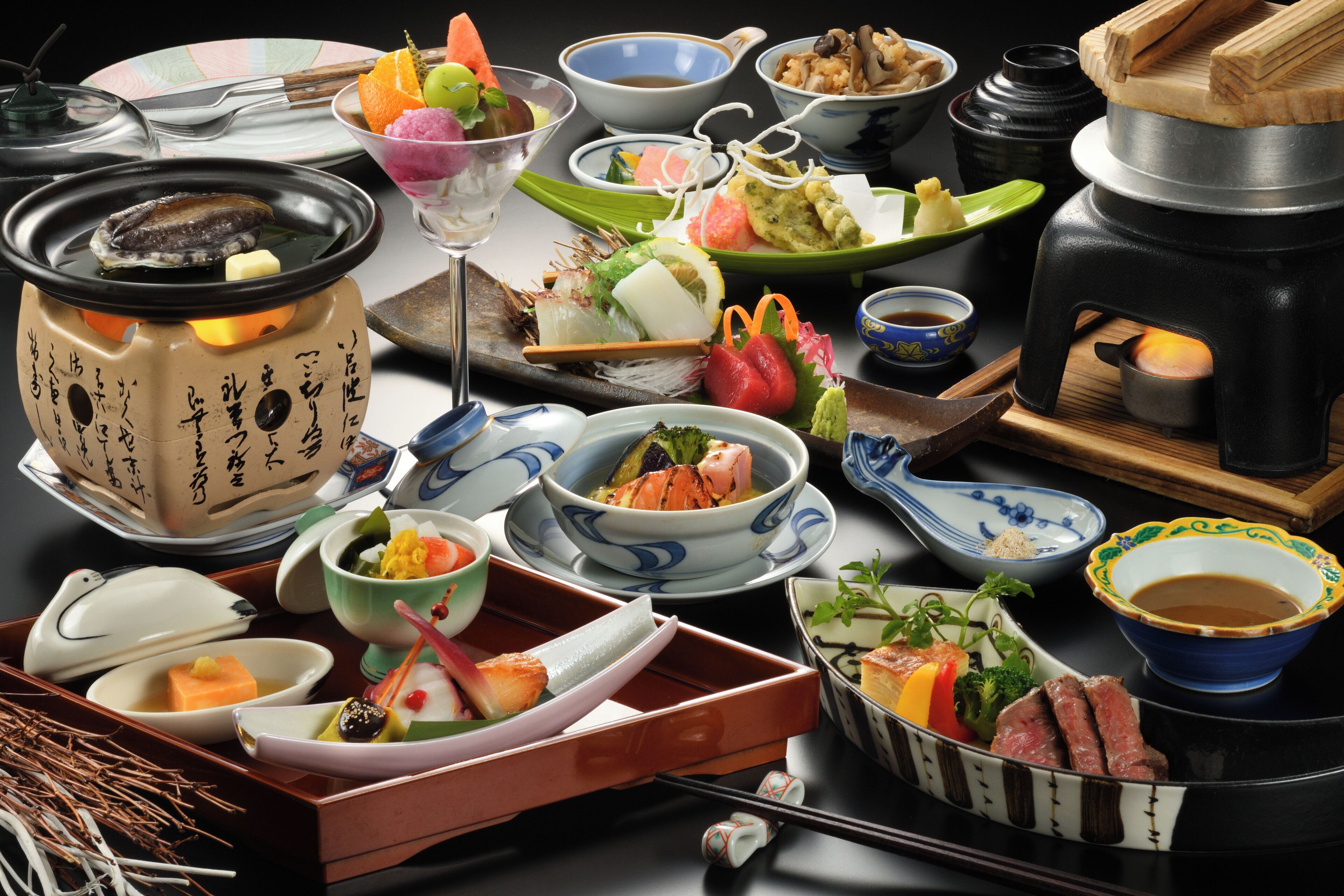 Una variedad de platos japoneses y una disposición tradicional para un caldo caliente.