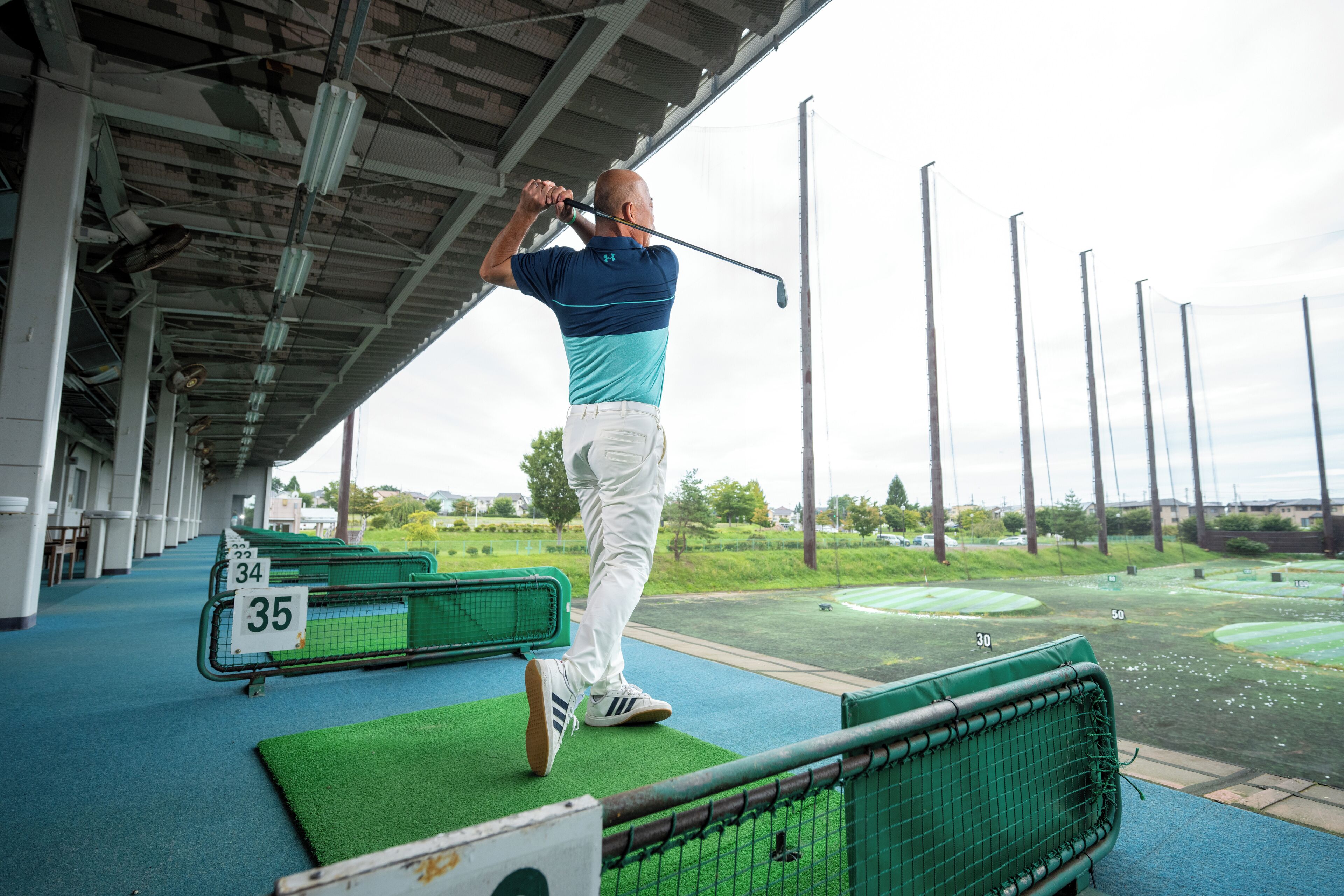 Un campo de golf con hoyos numerados y una zona de prácticas techada.
