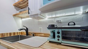A kitchen with a sink, a coffee maker, and a toaster oven. - Marietta Square Suites - Suite3 - Cozy Studio! (Marietta)