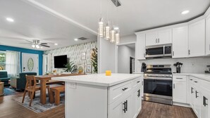 Een moderne keuken met witte kasten, roestvrijstalen apparatuur en een centraal eiland.