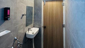 Ένα σύγχρονο μπάνιο με ντους, νιπτήρα και τουαλέτα.