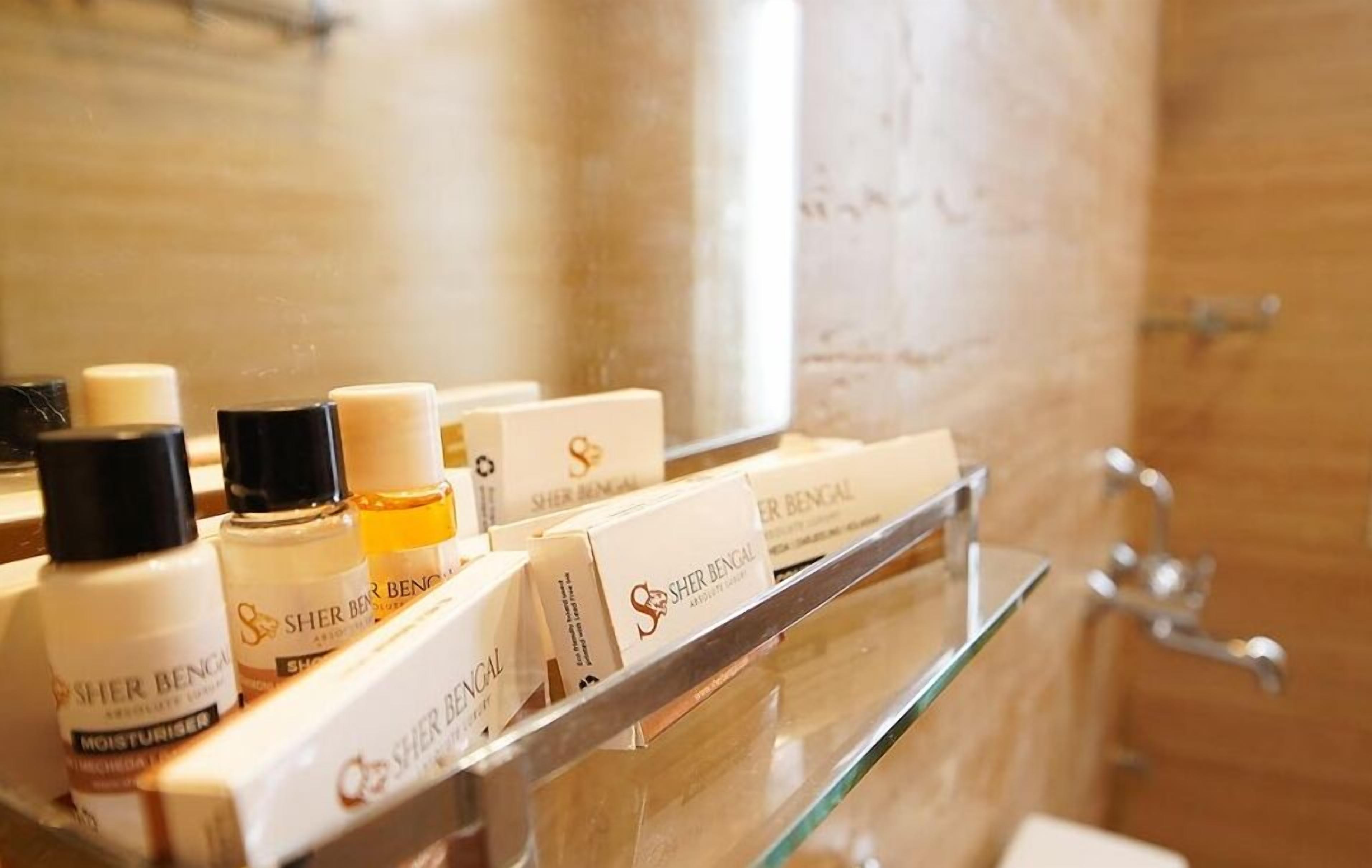 A bathroom shelf with toiletries and a mirror.
