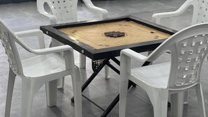 Une pièce comprenant une table et des chaises, une fenêtre avec des rideaux et un coin salon avec des fauteuils.