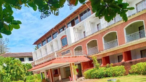 A multi-story building with balconies and a covered entrance. - Arnala Beach Resort (Vasai)