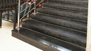 A staircase with metal railings and dark steps leading to an upper floor. - Hotel Sachidanand (Rahata)