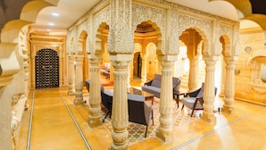 An ornate interior with high ceilings, intricate arches, and a checkered floor. - Hotel Durjay Garh (Jaisalmer)
