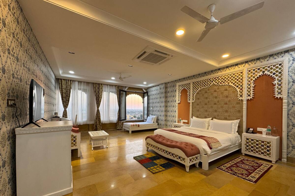 Une chambre d’hôtel spacieuse, dotée d’un grand lit, d’un bureau et d’une armoire.