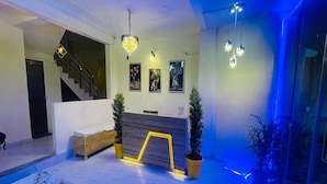 Un lobby moderno con una recepción, una escalera y un área de descanso.