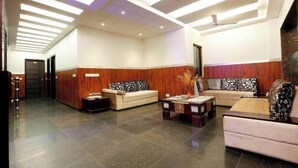 Una hall con una reception, due divani, un tavolino da caffè e una parete decorata.