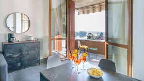 Habitació moderna amb taula de dinar, cadires, buffet i un gran finestral amb vista.