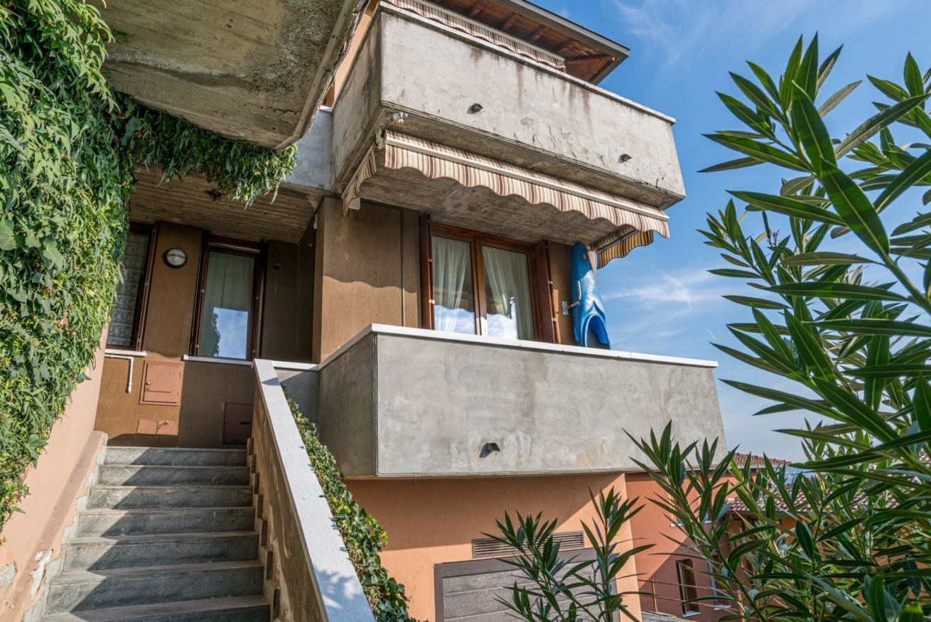 A two-story building with a balcony, a staircase, and a door with a window.