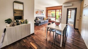 A modern kitchen with a dining area, a sofa, and a TV. - Nice apartment for 3 guests with WIFI, A/C, TV, patio and pets allowed (Lesa)