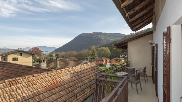 A balcony with a view of a mountain and surrounding buildings.