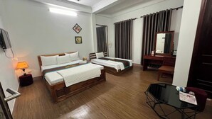 A hotel room with two beds, a desk, a chair, a small table, and a ceiling fan. - Huong Villa Hotel HN - by BAY LUXURY (Hanoi)