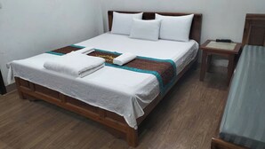 A neatly made bed with white linens, a brown headboard, and a wooden nightstand beside it. - Huong Villa Hotel HN - by BAY LUXURY (Hanoi)