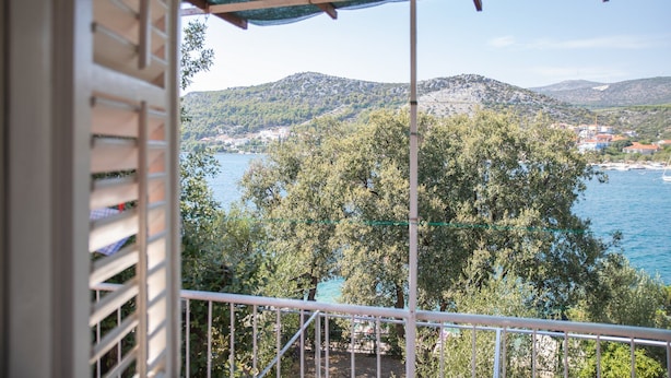 A balcony with a view of a coastal town and hills. - Perfect Beachfront Getaway Ideal for Families (Seget)