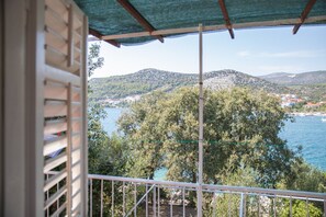 A balcony with a view of a coastal town and hills. - Perfect Beachfront Getaway Ideal for Families (Seget)