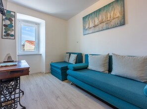 Apartment (One Bedroom Apartment with Terrace) | Living room | 32-inch flat-screen TV with satellite channels - Apartments Bionda (Novi Vinodolski)