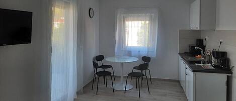 A small, modern kitchen with a dining area.