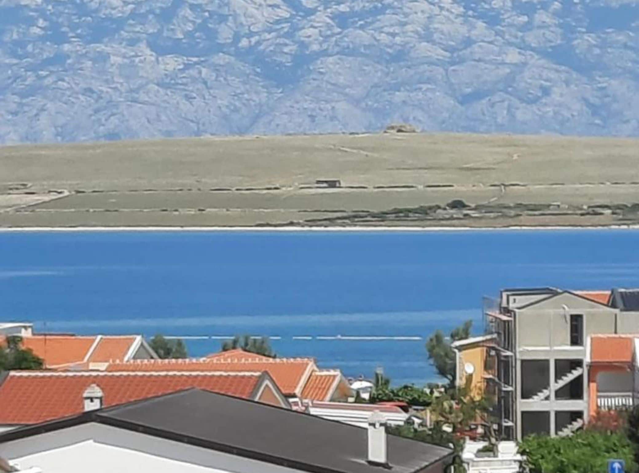 A coastal view with buildings and a clear blue sea.