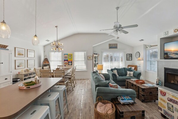 A spacious living area with a dining table, sofas, and a fireplace.