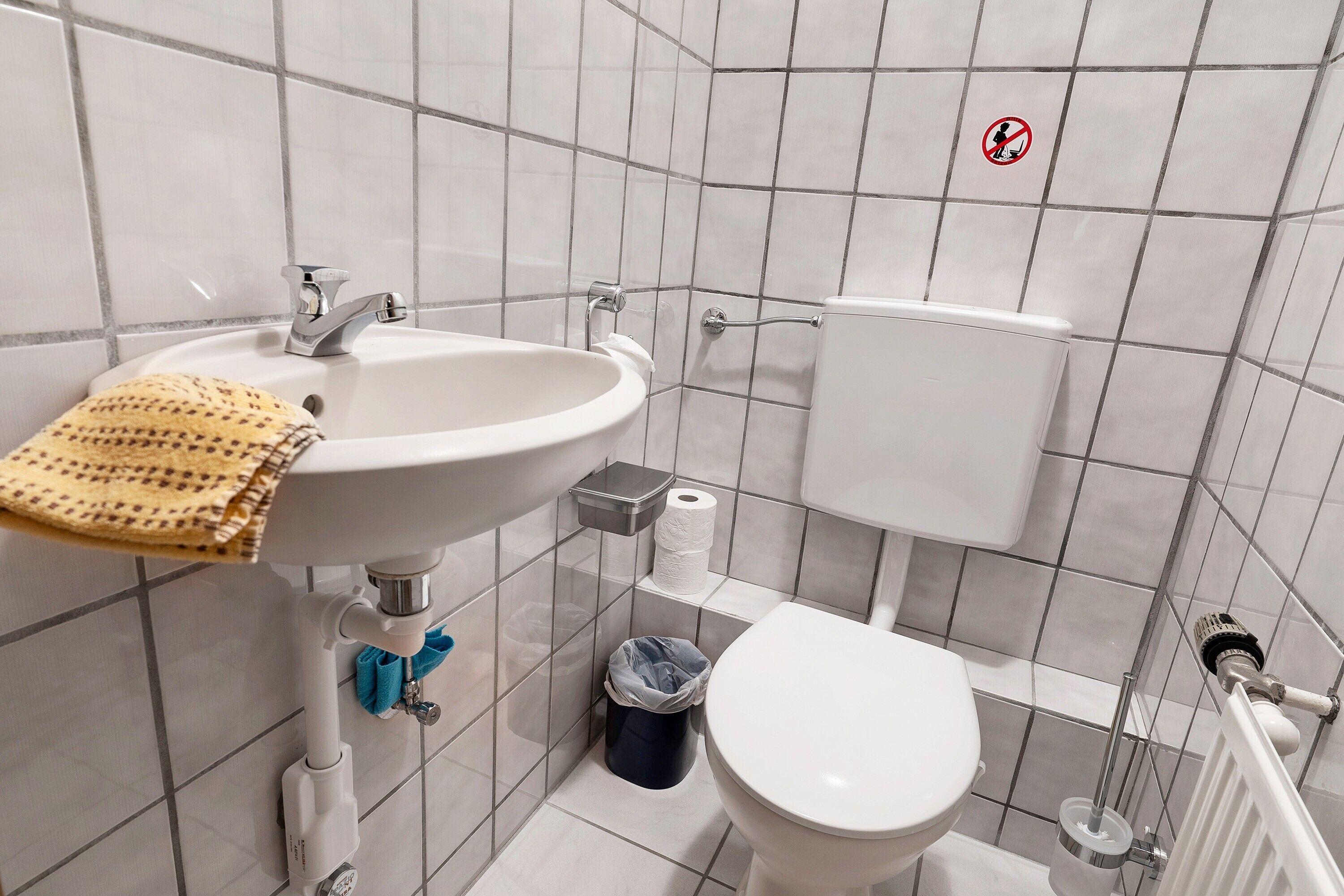 Une salle de bain avec un lavabo, des toilettes et un bidet, le tout de couleur blanche.