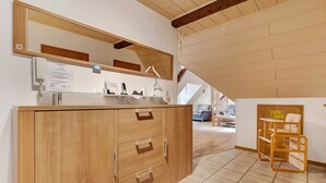 Un meuble en bois avec des tiroirs, un miroir et un téléphone.