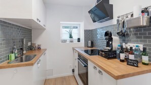 Una cocina moderna con encimera de madera, electrodomésticos de acero inoxidable y ventana con vistas.