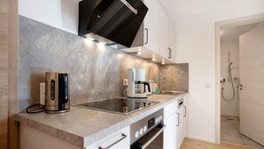 Uma cozinha moderna com forno embutido, cafeteira e micro-ondas.