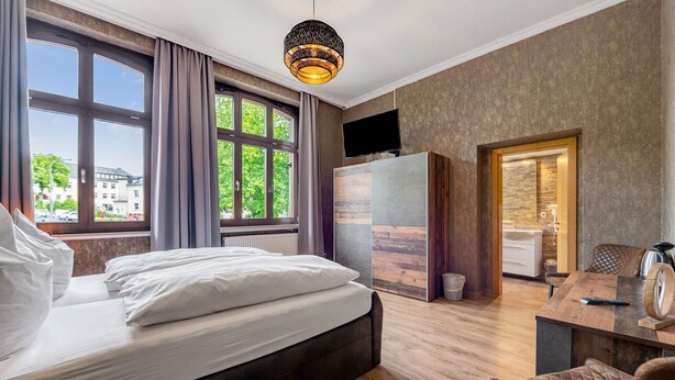 A bedroom with a bed, a desk, a chair, a television, and a window with curtains. - Room 'Zimmer 2' with Wi-Fi (Prüm)