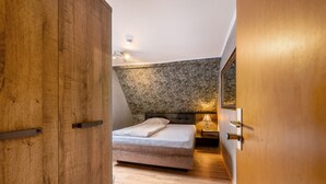 Ein Schlafzimmer mit einem Bett, einem Holzschrank und einer Wand mit Steinmuster.