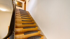 Eine Holztreppe mit Teppichbelag und Handlauf.
