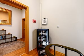 Un couloir avec un distributeur automatique, un miroir et un tableau encadré accroché au mur.