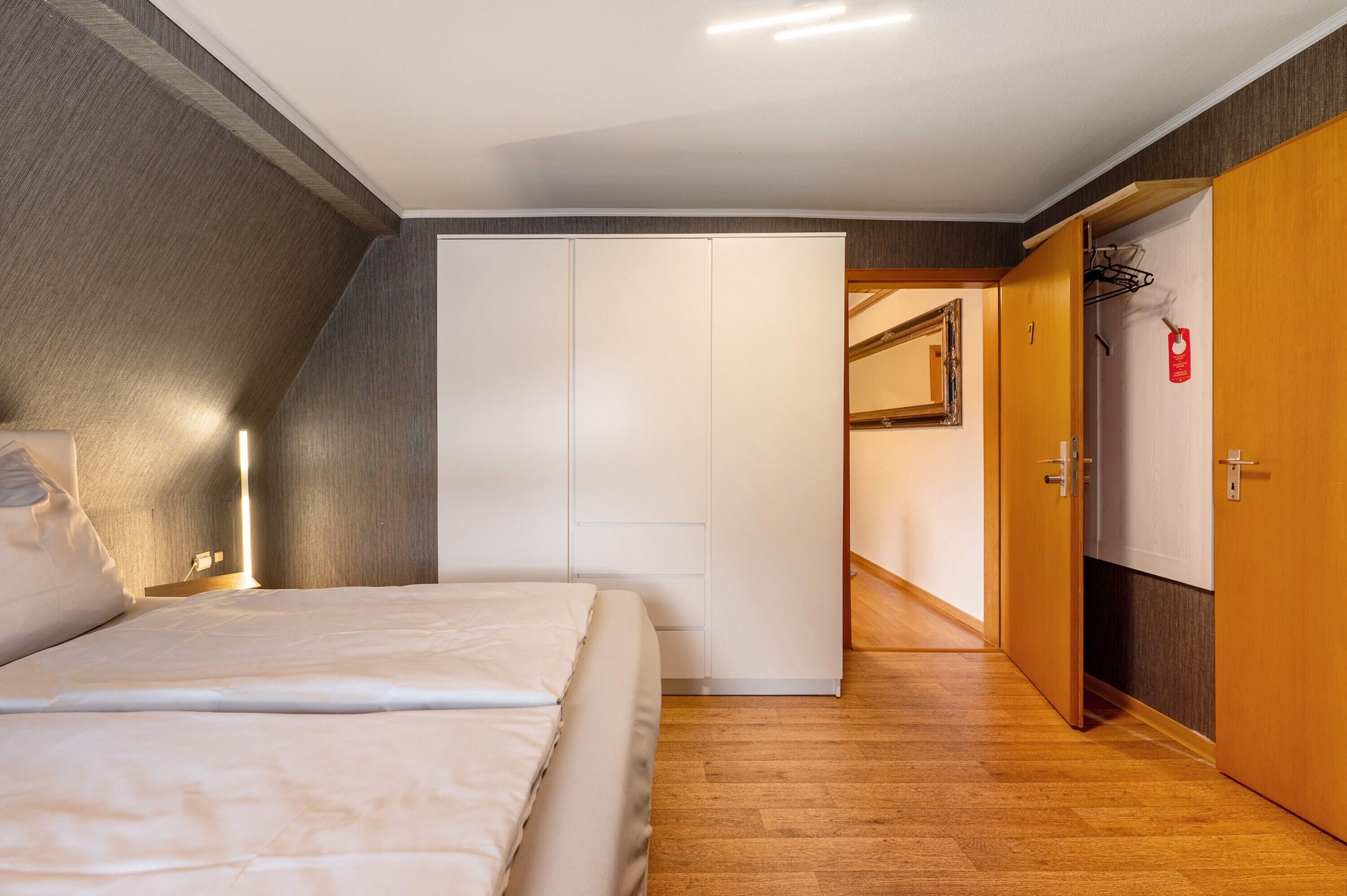 Ein Schlafzimmer mit Bett, Kleiderschrank und begehbarem Kleiderschrank.