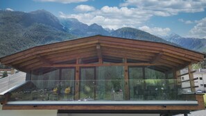 A modern wooden building with large glass windows, a sloped roof, and a view of mountains. - Apartment 'Appartement Gletscherblick' with Mountain View, Private Terrace and Wi-Fi (Medraz)